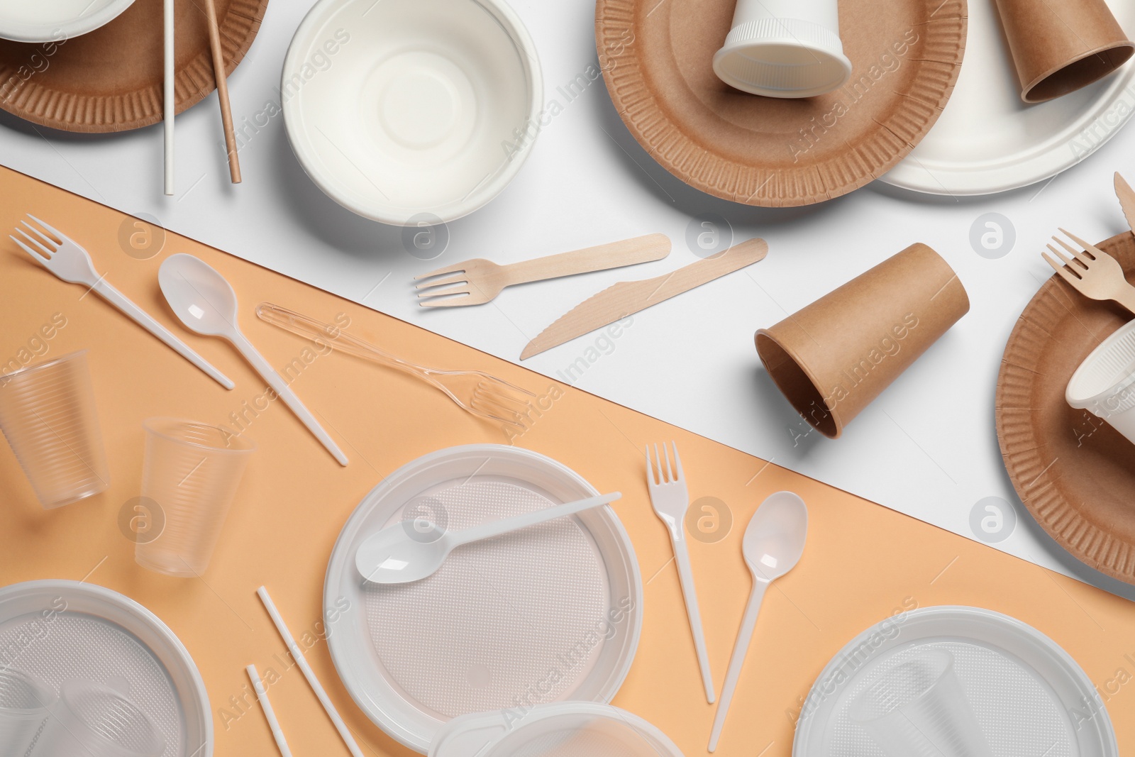 Photo of Flat lay composition with plastic and eco disposable tableware on color background