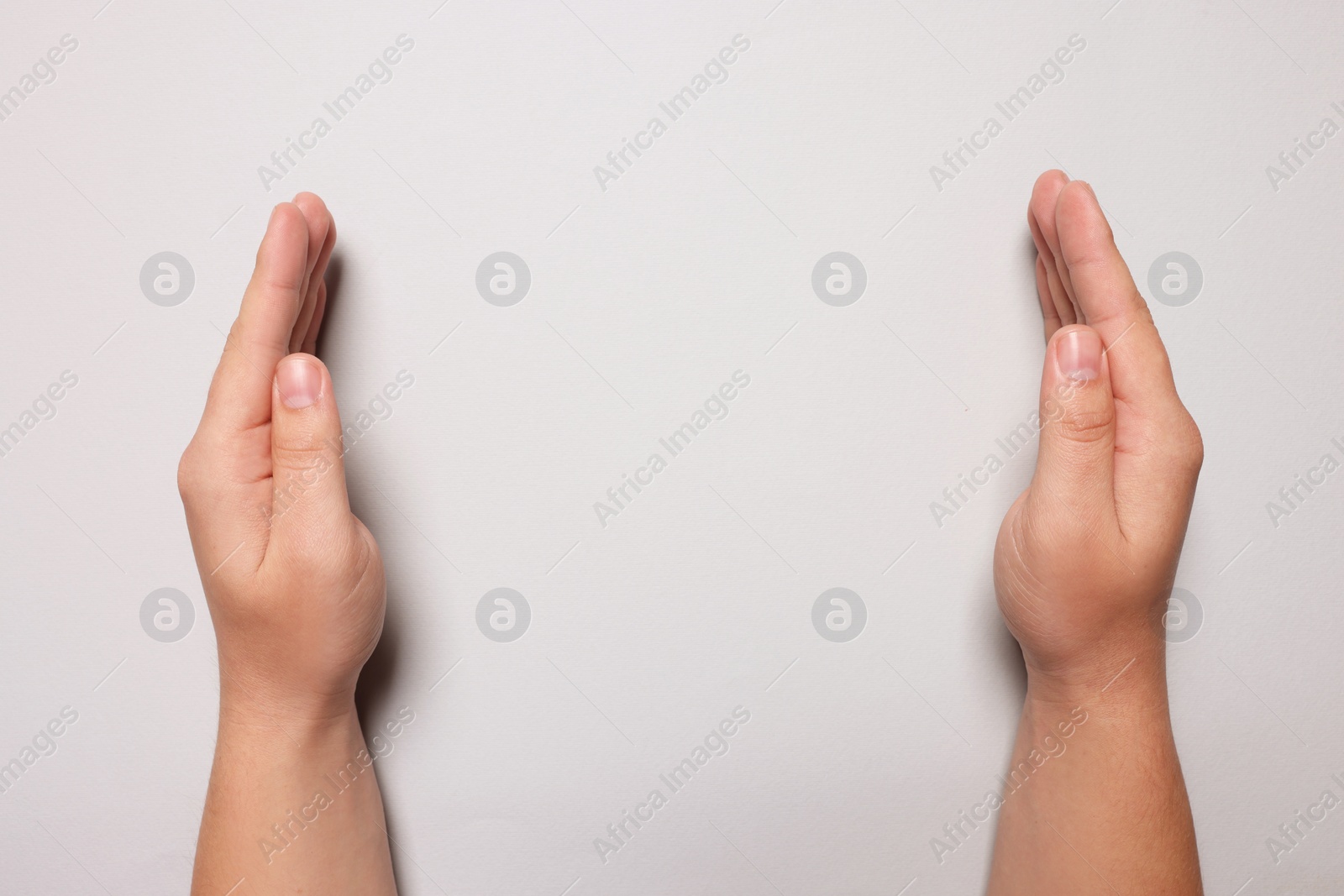 Photo of Woman holding on light grey background, closeup of hands. Space for text