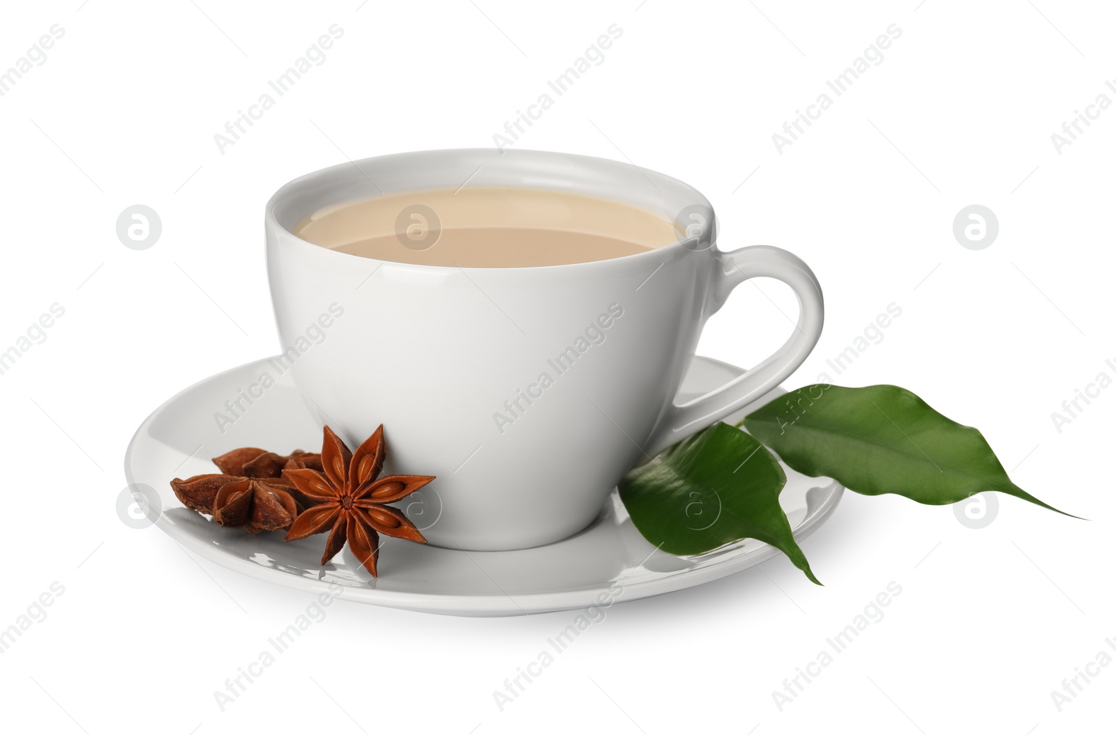 Photo of Cup of tea with milk, anise stars and green leaves on white background