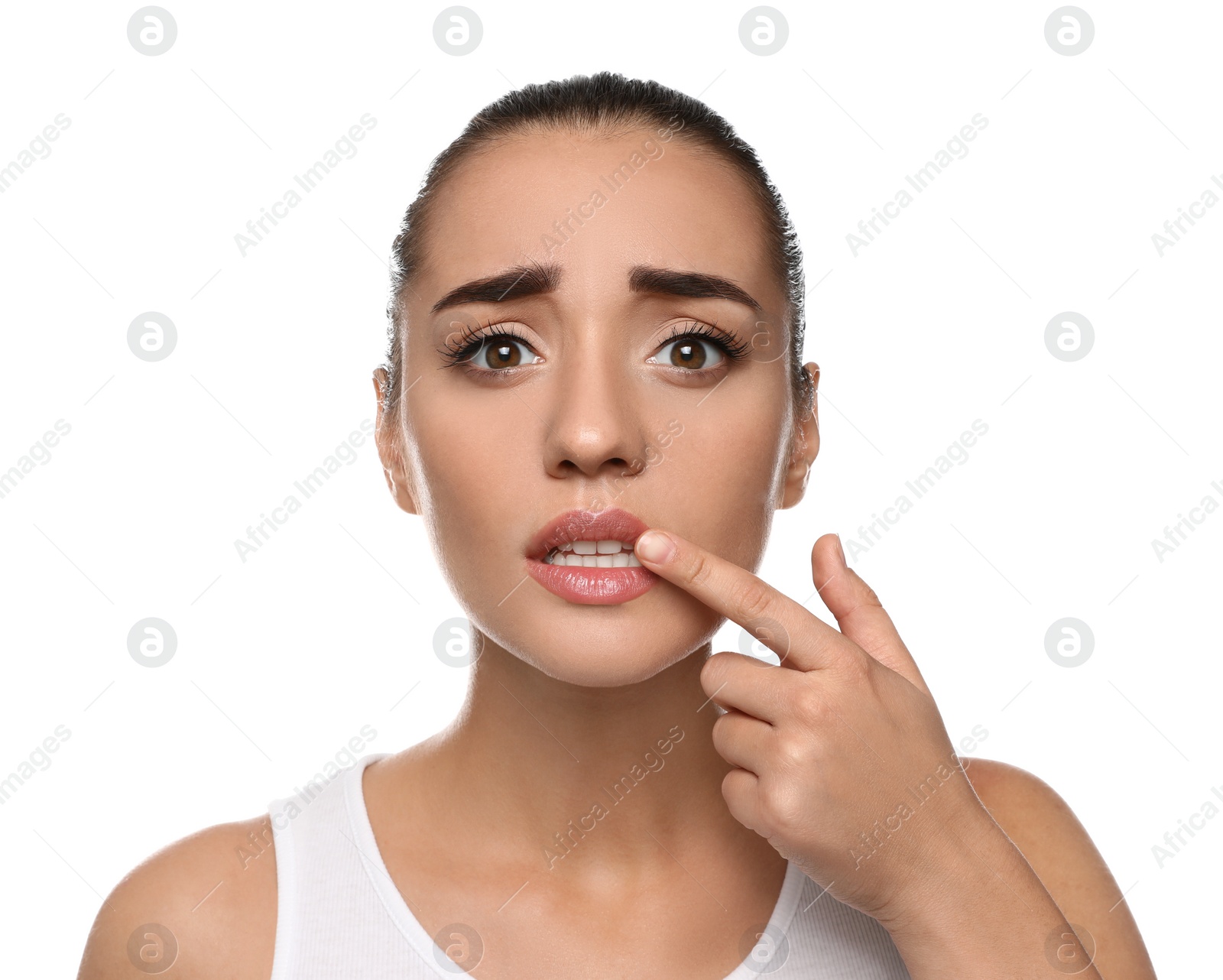 Photo of Emotional woman with herpes touching lips on white background