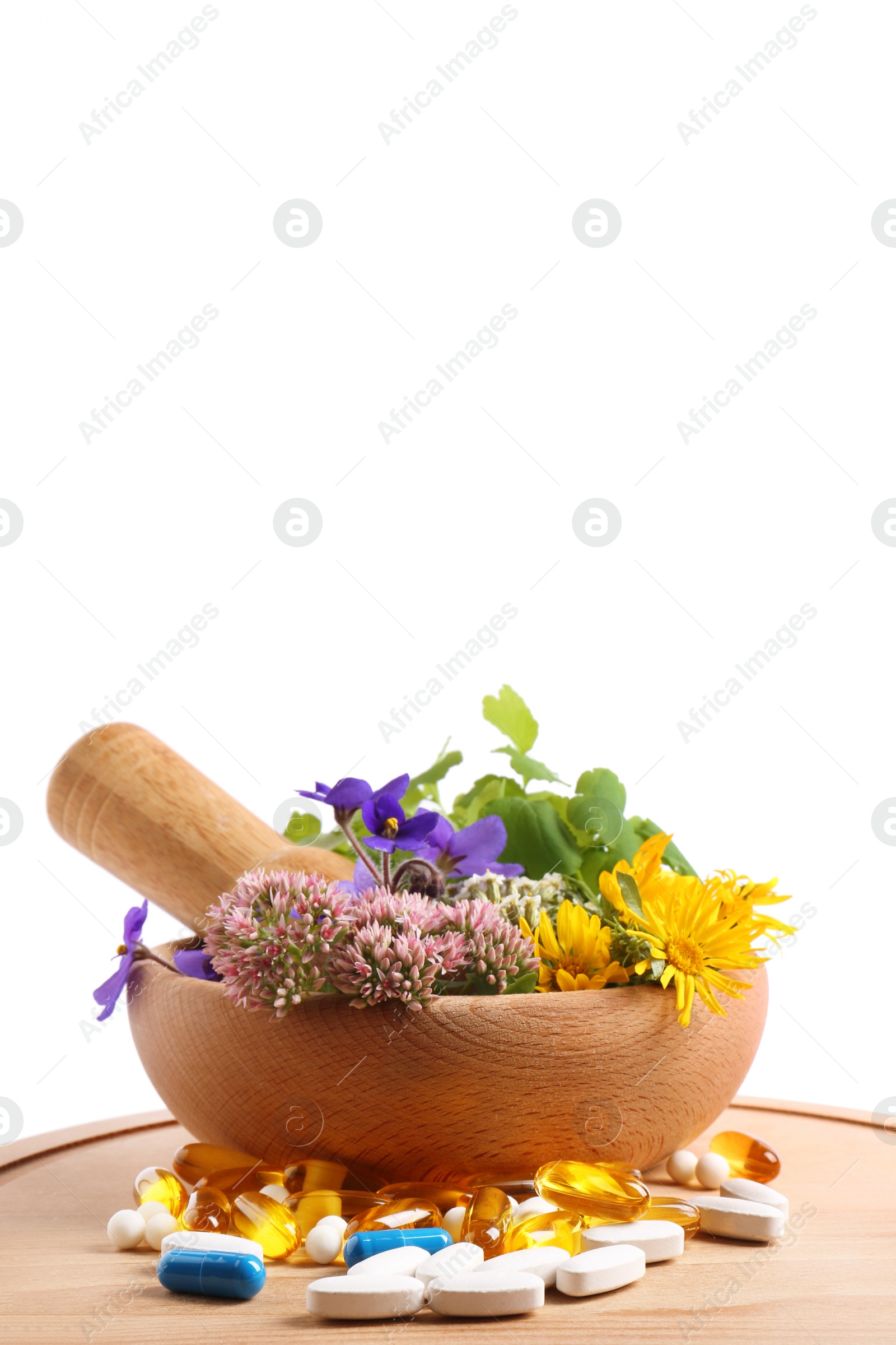 Photo of Board with mortar, fresh herbs and pills on white background