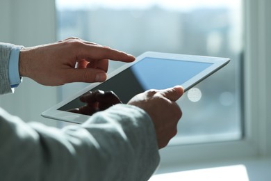 Closeup view of man using new tablet indoors