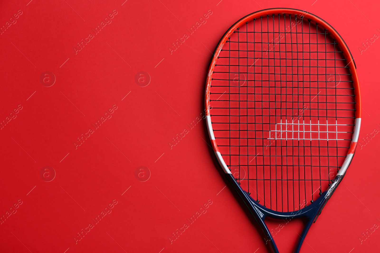 Photo of Tennis racket on red background, top view. Space for text