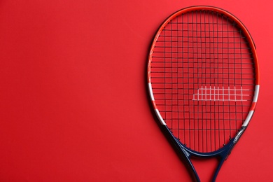 Tennis racket on red background, top view. Space for text