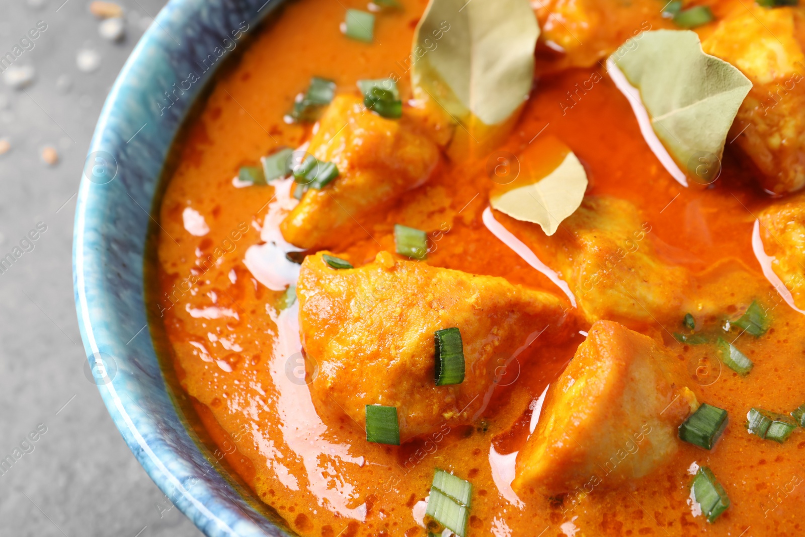 Photo of Bowl of delicious chicken curry on table, closeup