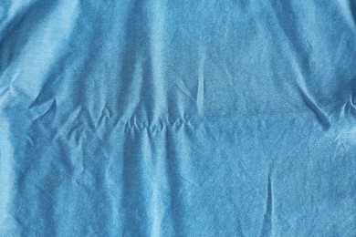 Photo of Crumpled light blue fabric as background, top view
