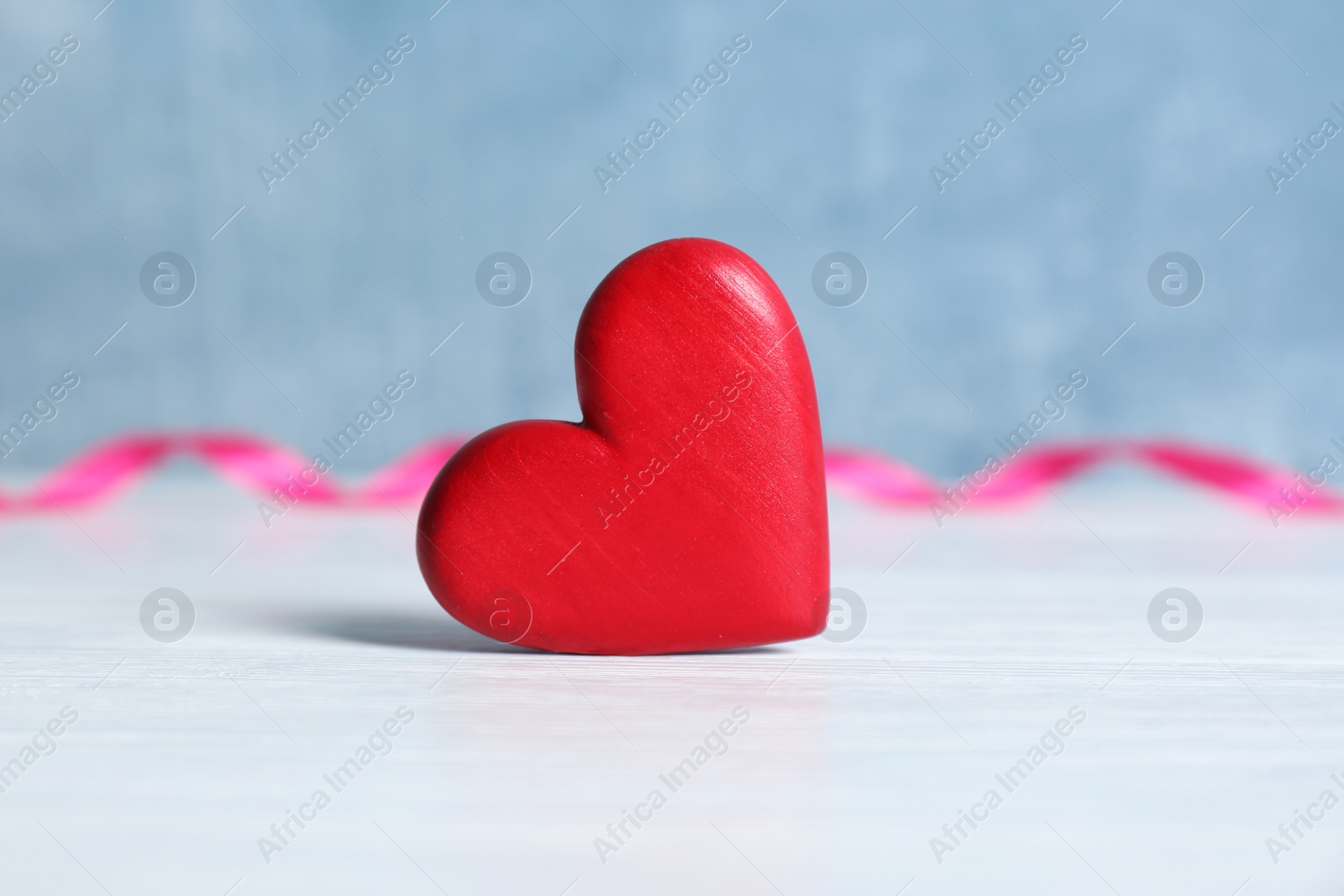 Photo of Red decorative heart as symbol of love on table