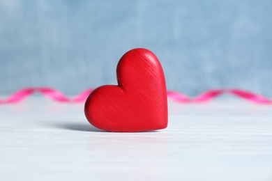 Red decorative heart as symbol of love on table