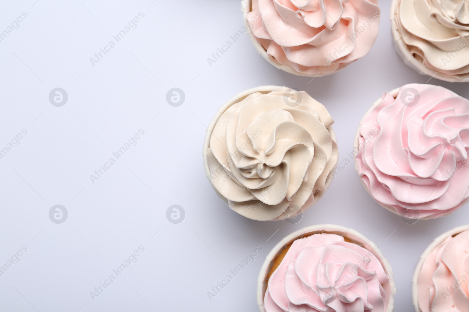 Photo of Many tasty cupcakes on white background, flat lay. Space for text