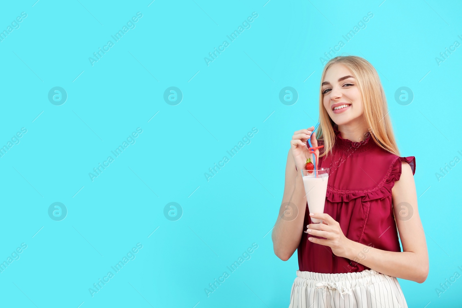 Photo of Young woman with glass of delicious milk shake on color background