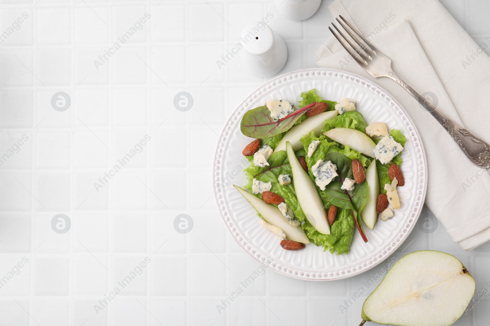 Photo of Delicious pear salad served on white tiled table, flat lay. Space for text