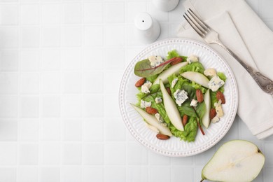 Photo of Delicious pear salad served on white tiled table, flat lay. Space for text