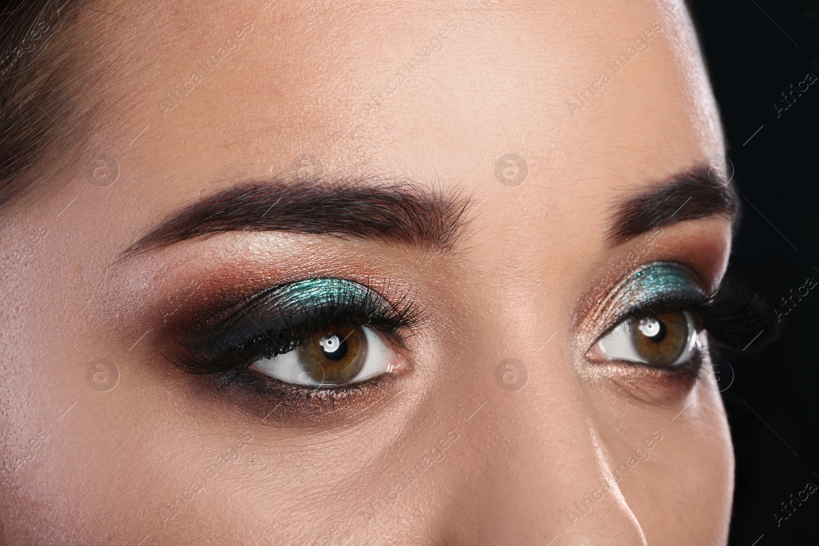 Photo of Young woman with eyelash extensions and beautiful makeup, closeup view