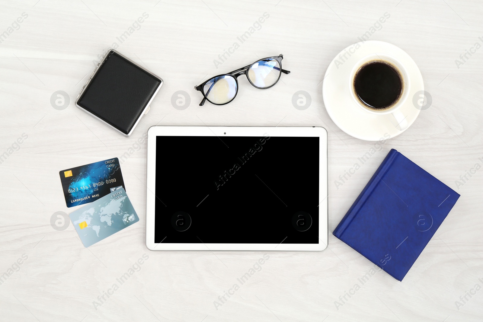 Photo of Online store. Tablet, credit cards, stationery, glasses and coffee on white wooden table, flat lay