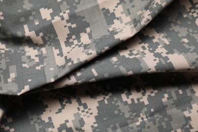 Photo of Texture of crumpled camouflage fabric as background, top view