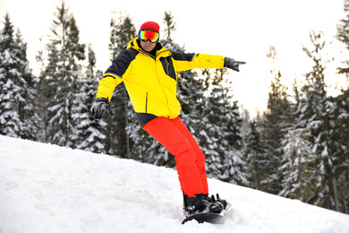 Male snowboarder on snowy hill. Winter vacation