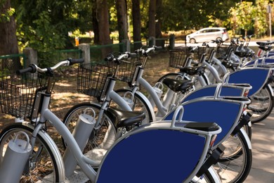 Parking rack with many bicycles outdoors. Bike rental