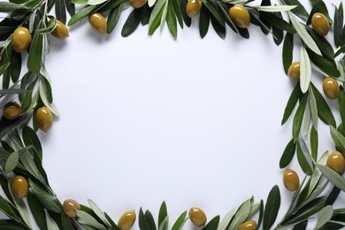 Frame made of fresh green olives and leaves on white background, flat lay. Space for text