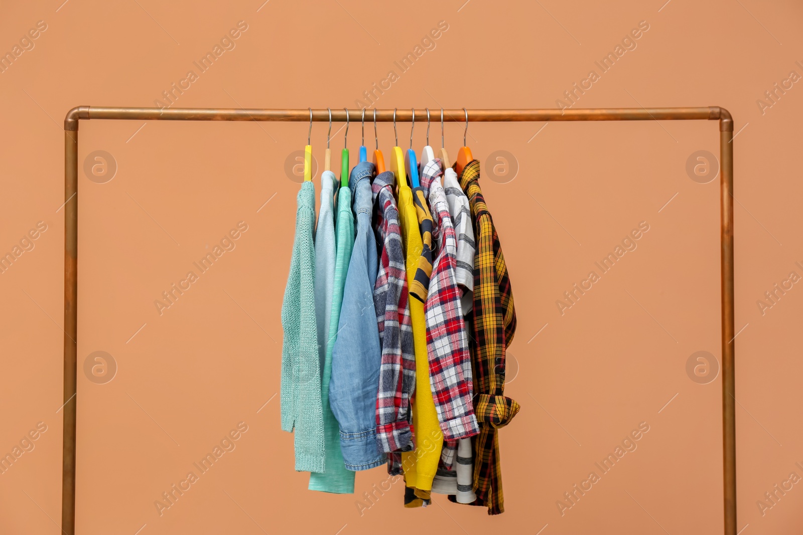 Photo of Rack with stylish children clothes on beige background