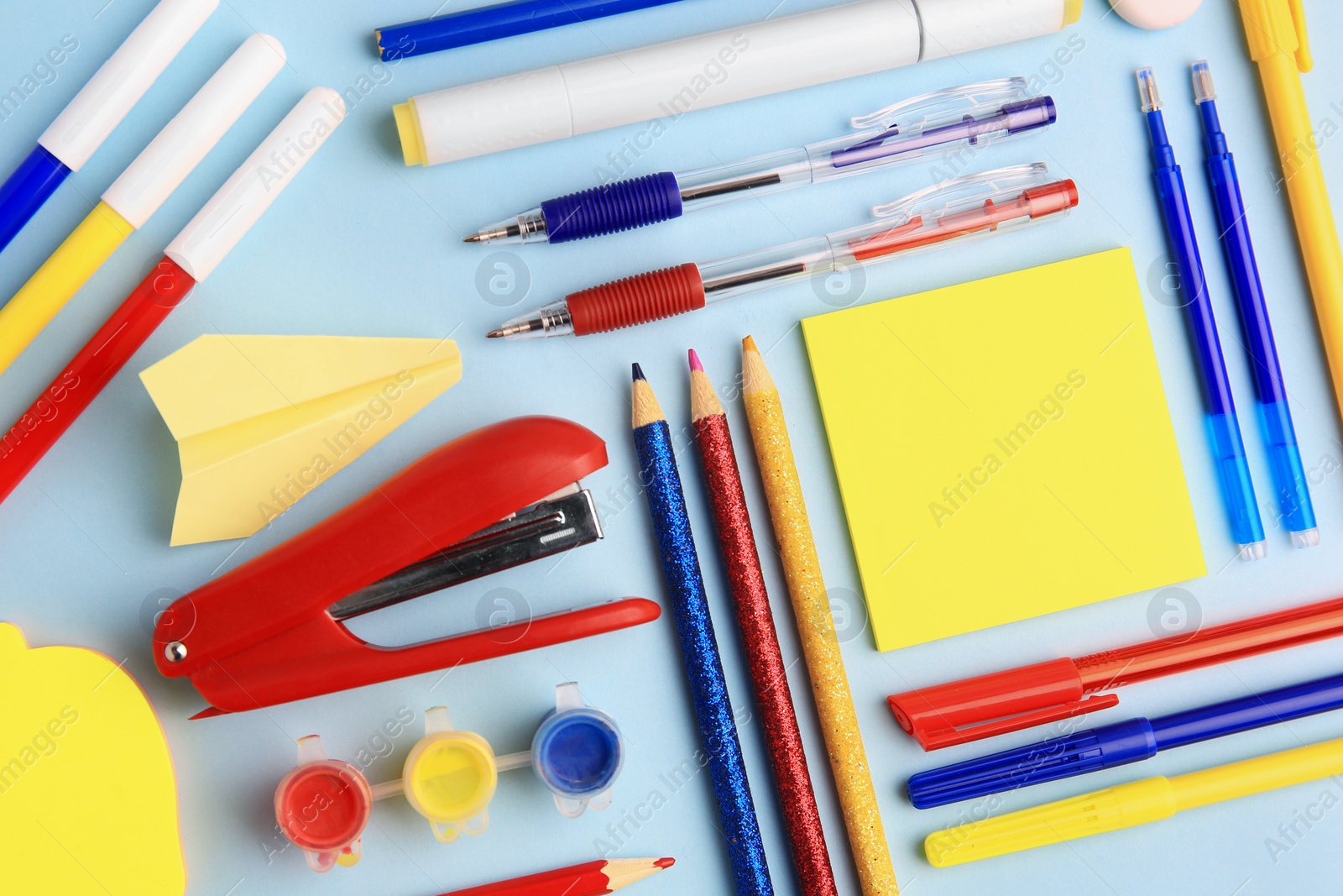 Photo of Flat lay composition with sticky note and other school stationery on light blue background, space for text. Back to school