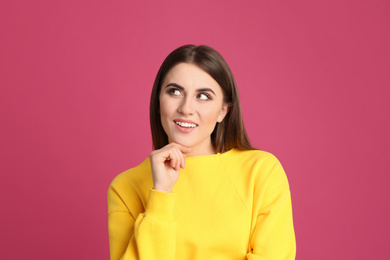 Photo of Portrait of happy young woman on pink background