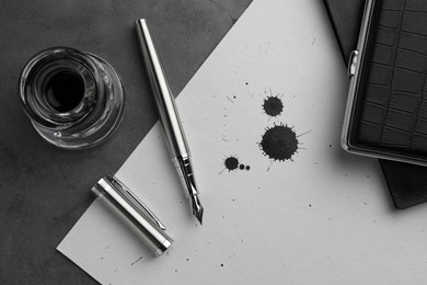 Photo of Flat lay composition with stylish fountain pen on grey textured table