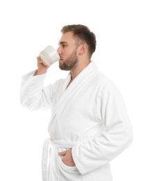 Handsome man in bathrobe with cup of coffee on white background