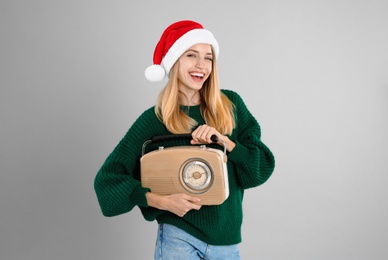 Photo of Happy woman with vintage radio on grey background. Christmas music