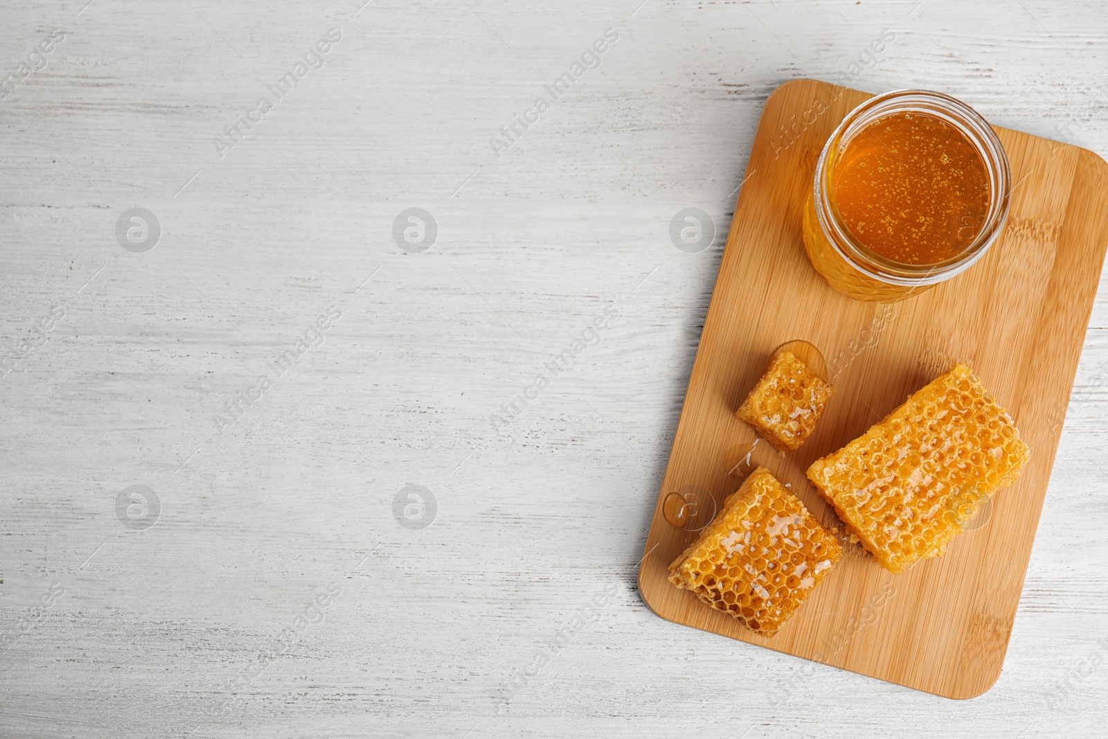 Photo of Composition with delicious honey on white wooden table, top view. Space for text