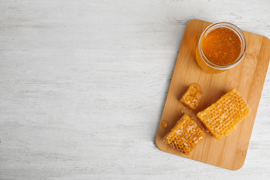 Photo of Composition with delicious honey on white wooden table, top view. Space for text