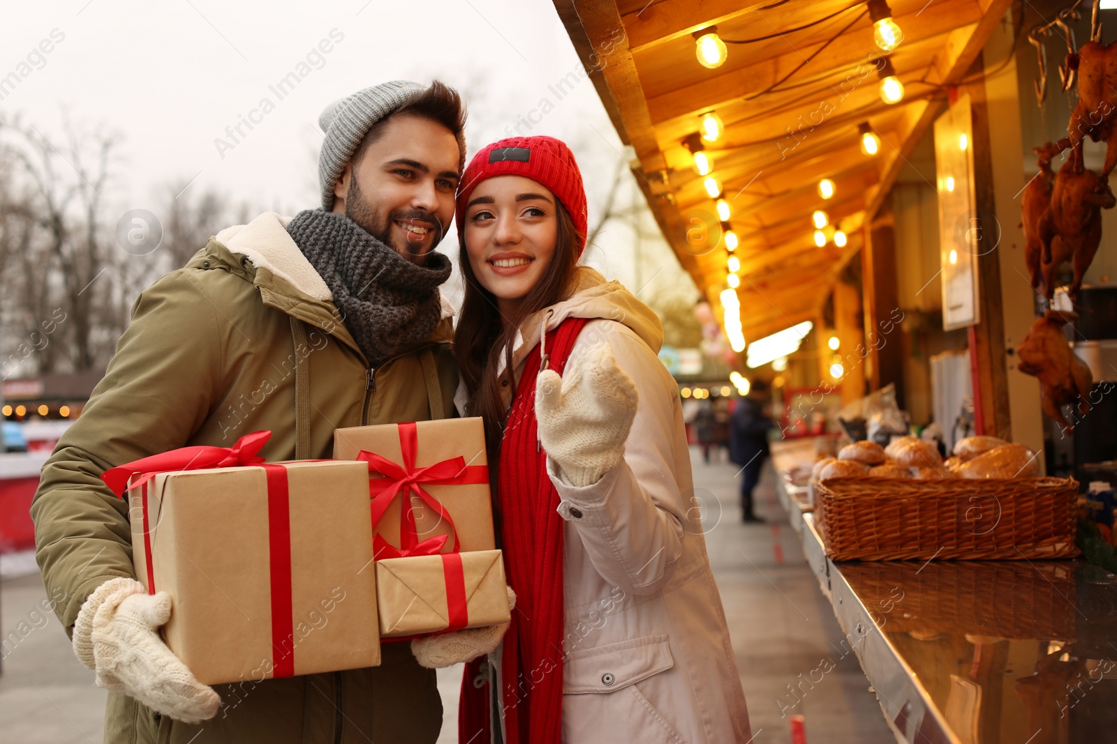 Photo of Lovely couple with Christmas presents at winter fair