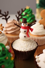 Tasty Christmas cupcake with snowman on table