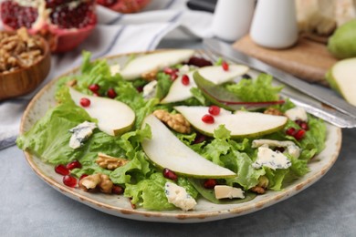 Photo of Delicious pear salad on grey textured table, closeup