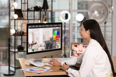 Professional retoucher working on computer in office