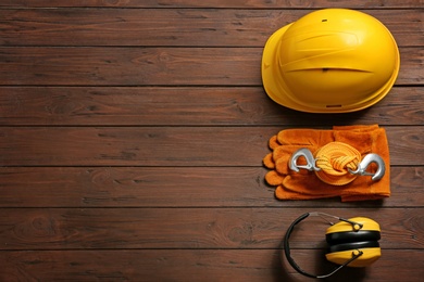 Photo of Flat lay composition with safety equipment and space for text on wooden background