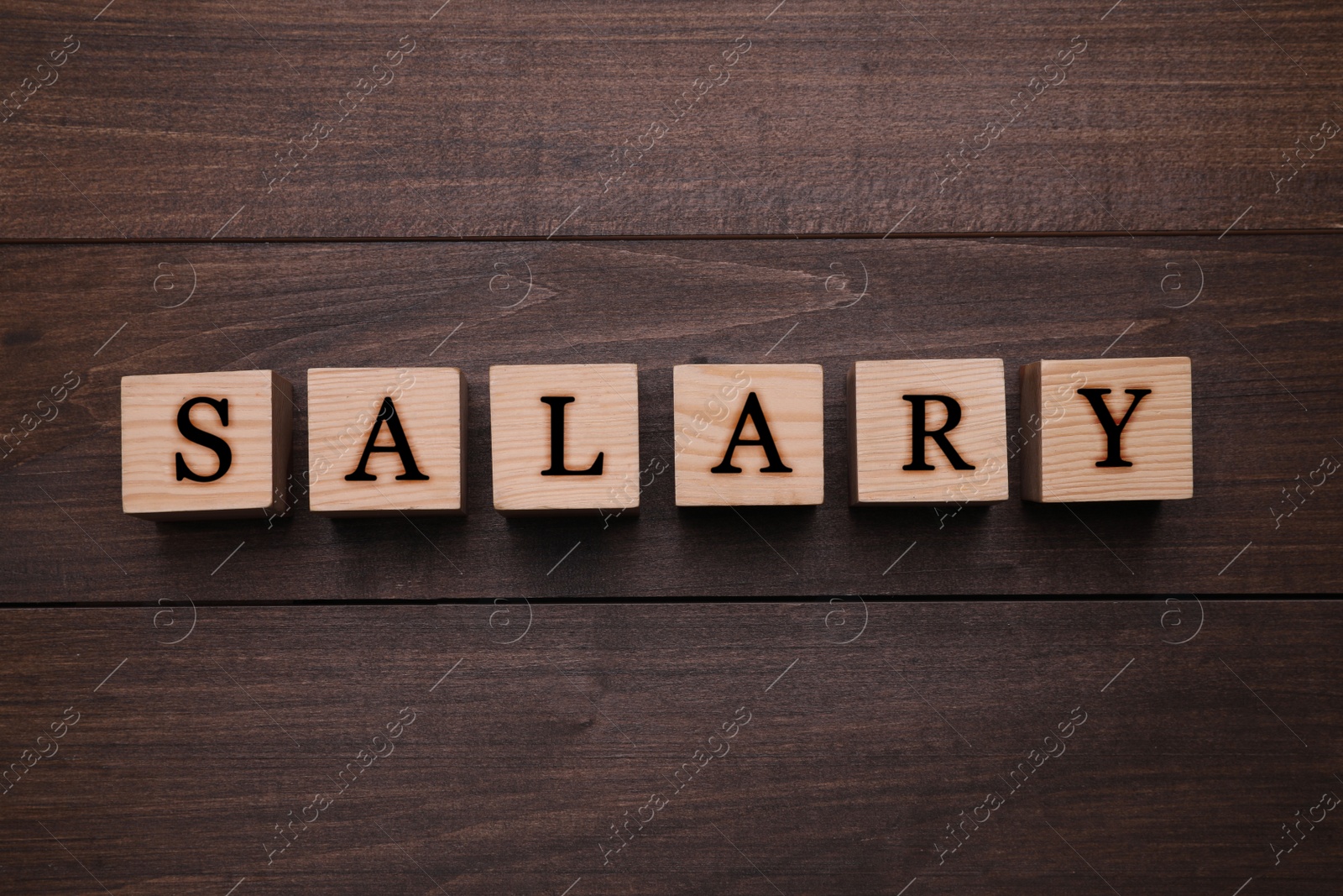 Image of Word Salary made with cubes on wooden table, flat lay