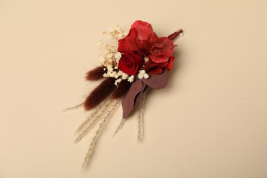 Stylish red boutonniere on beige background, top view