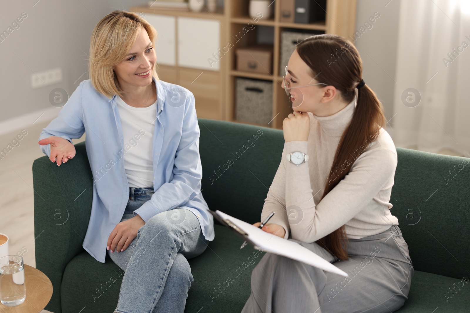 Photo of Psychotherapist working with patient on sofa in office