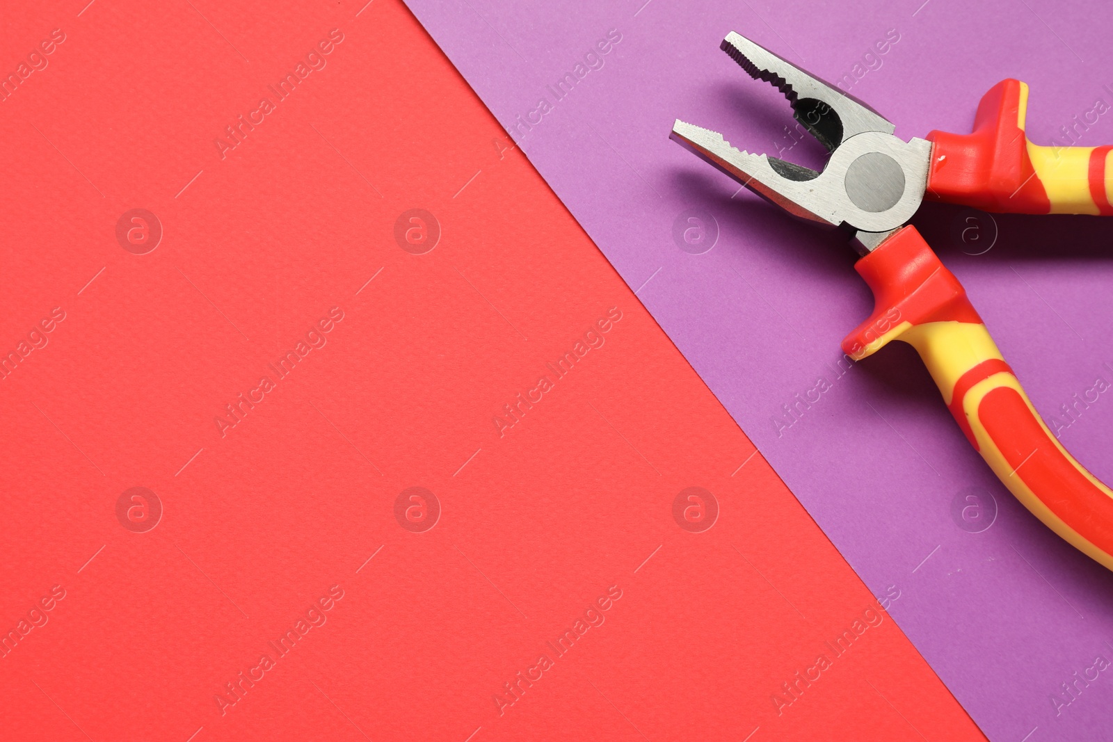 Photo of Combination pliers on color background, top view. Space for text