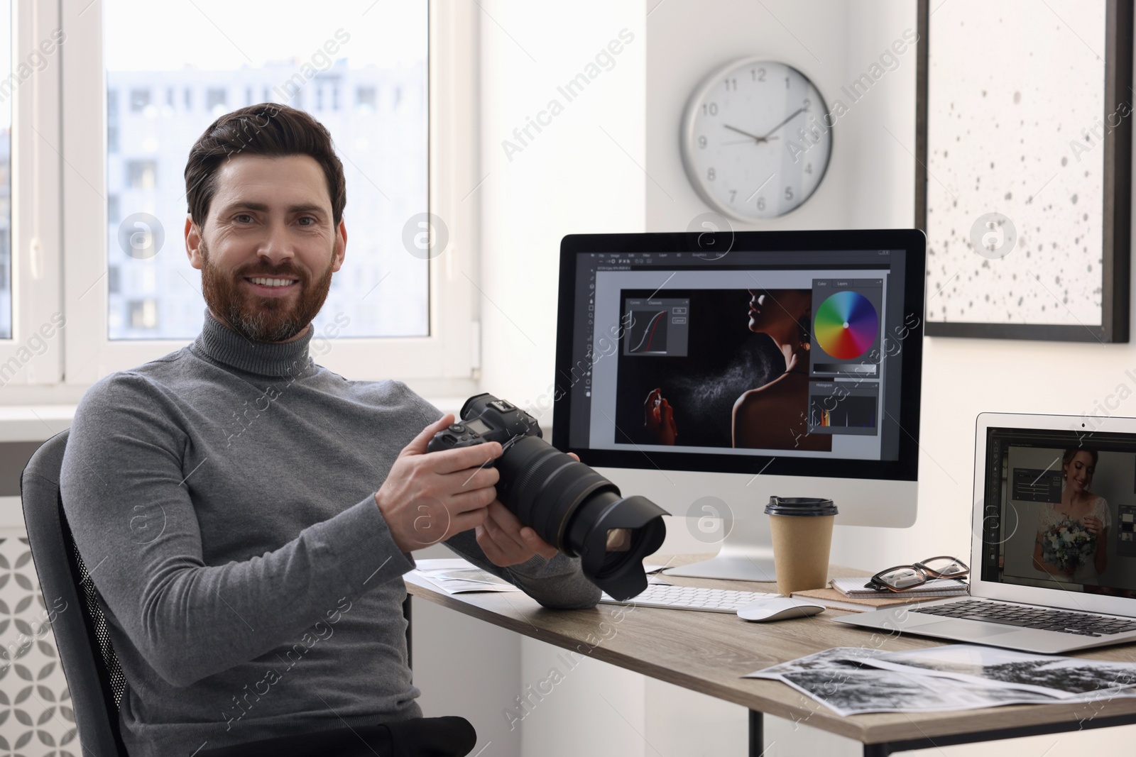 Photo of Professional photographer with digital camera at table in office