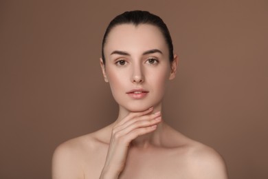 Photo of Portrait of beautiful young woman on light brown background