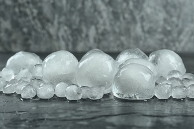 Photo of Many melting ice balls on dark table