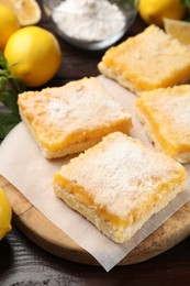 Photo of Tasty lemon bars with powdered sugar on table, closeup