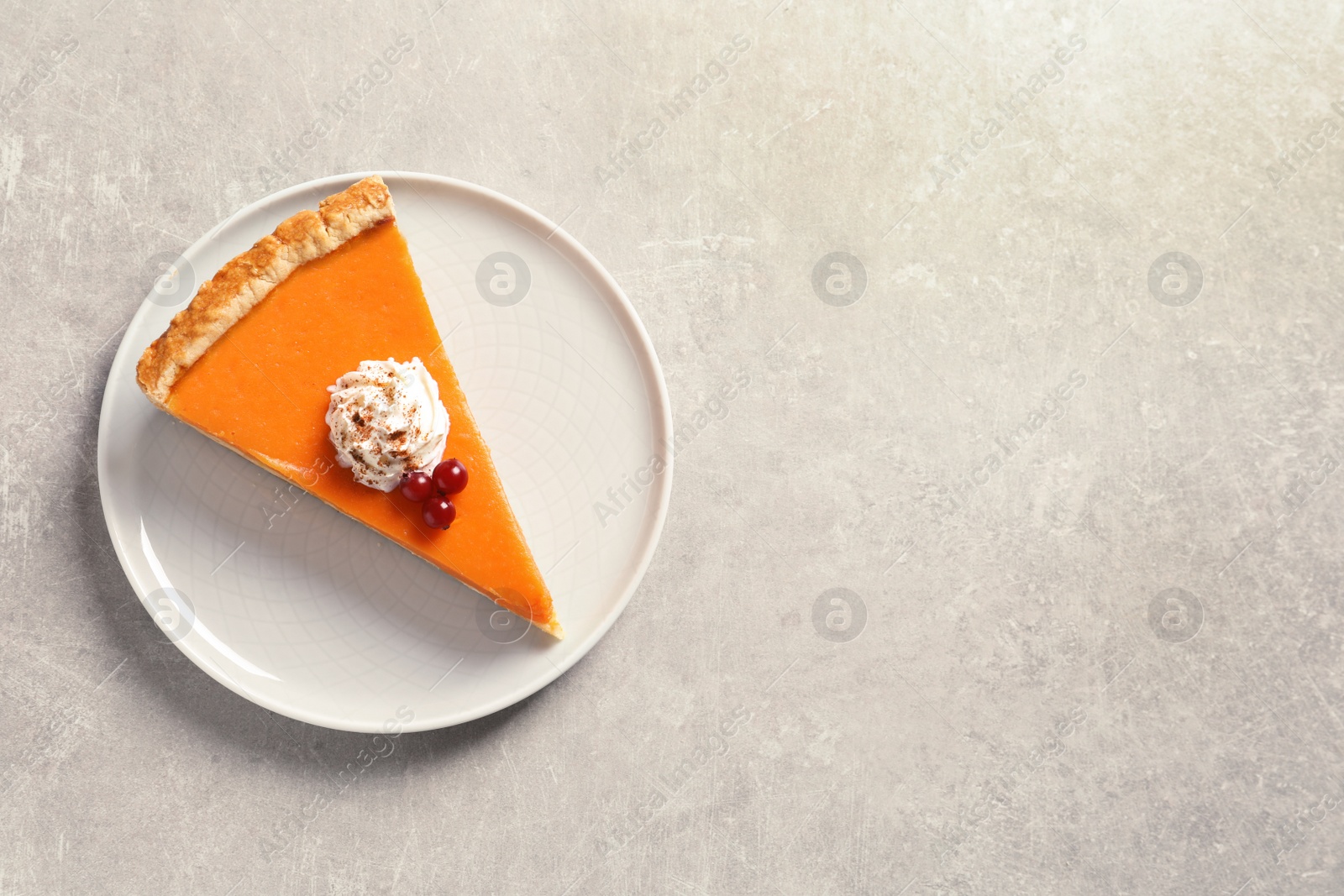 Photo of Plate with piece of fresh delicious homemade pumpkin pie on gray background, top view. Space for text