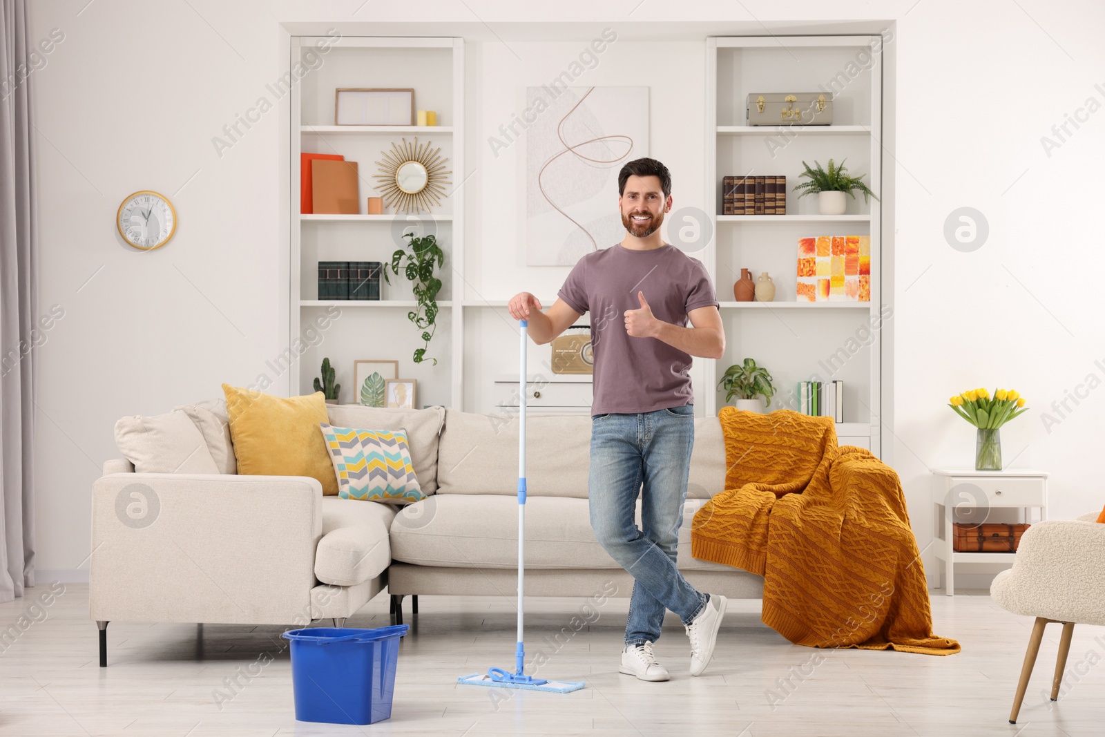 Photo of Spring cleaning. Man with mop washing floor at home