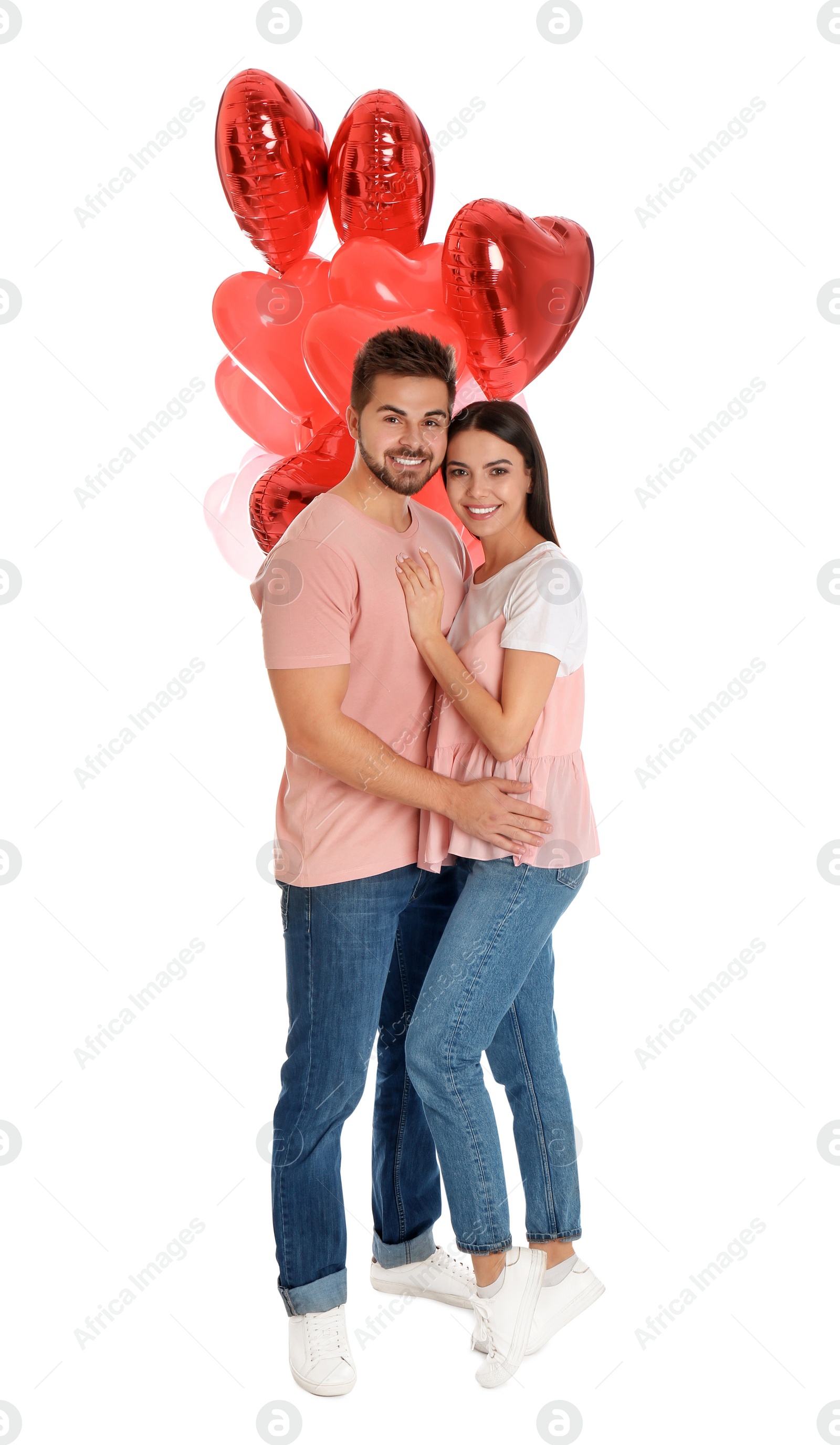 Photo of Happy young couple with heart shaped balloons isolated on white. Valentine's day celebration