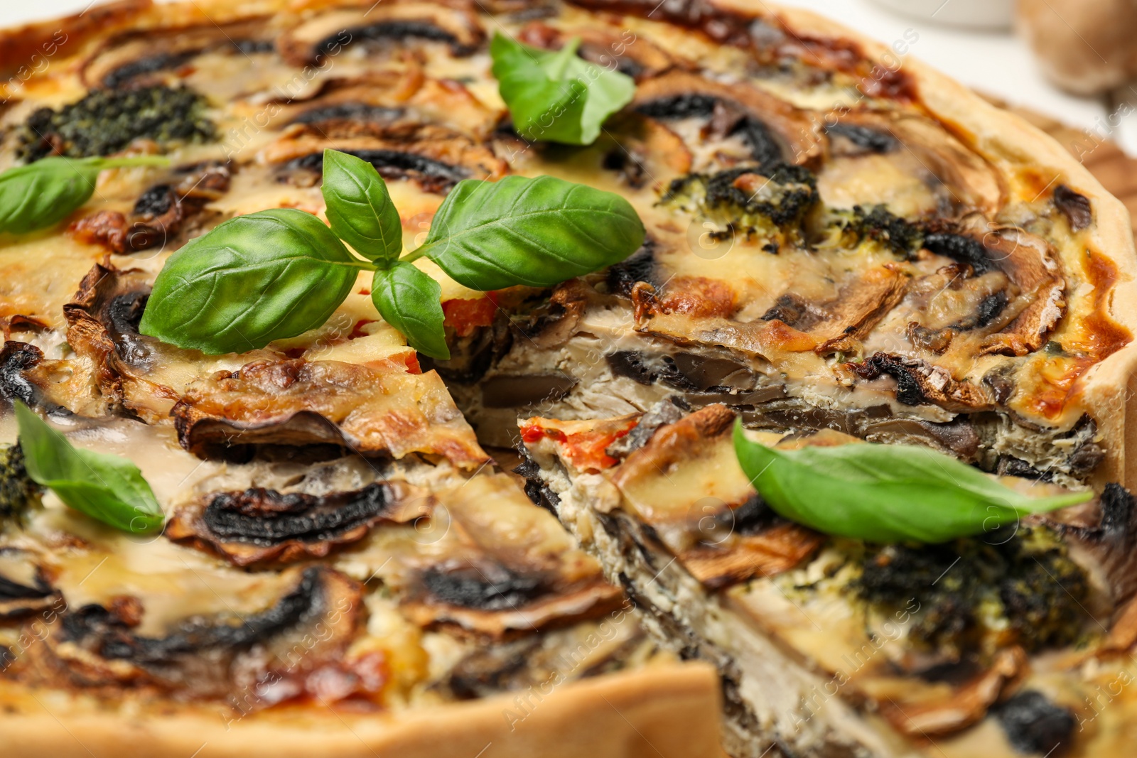 Photo of Delicious quiche with mushrooms and basil, closeup