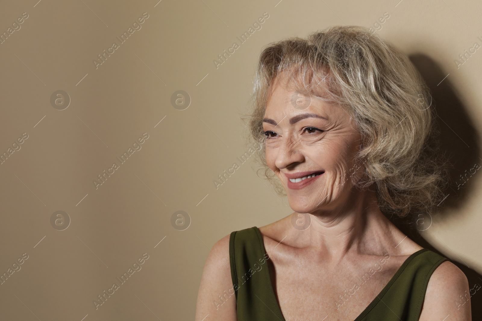 Photo of Portrait of mature woman on color background. Space for text