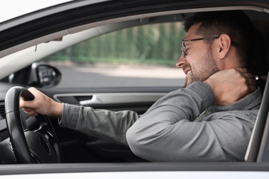 Man suffering from neck pain in car