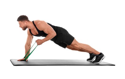 Photo of Young man exercising with elastic resistance band on fitness mat against white background